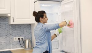 Donna che sbrina il freezer