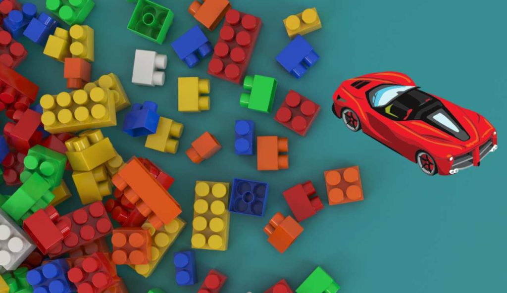 Illustrazione di alcuni mattoncini e di una Ferrari (Canva FOTO) - managementcue.it